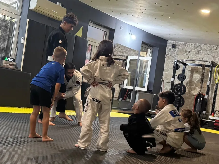 Antrenor explicând o tehnică grupei de copii la antrenamentul de BJJ de la Eden Combat Academy din Brașov